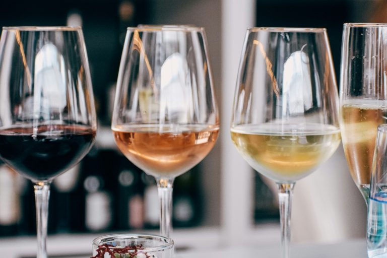 our exquisite extras include a wine hamper, ideal for celebrations. Image shows three wine glasses holding red, white and rose wine.